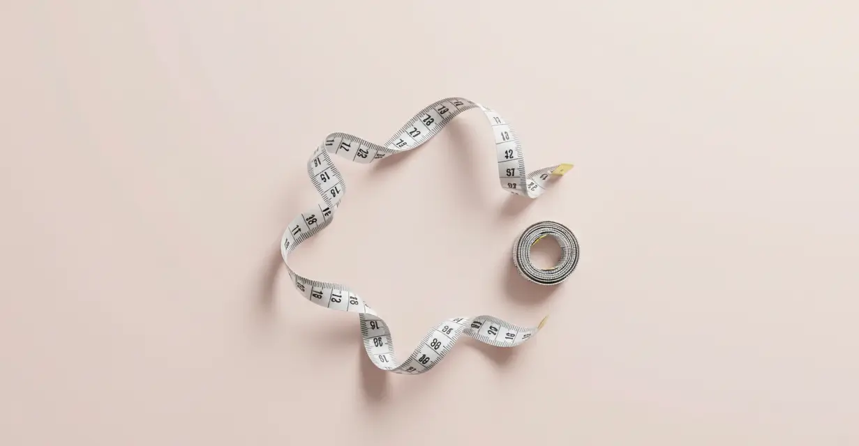 Measuring tape on pink background representing double d breast size measurement guide